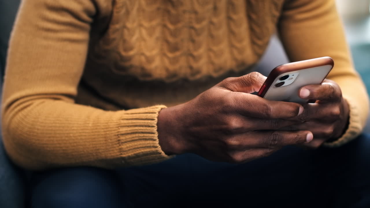 A black man is using his smartphone in an office