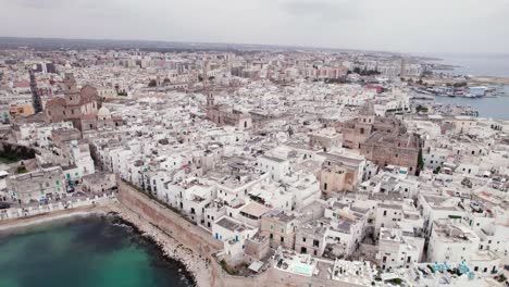 aerial view of monopoli old city with white building on sea coast, puglia, italy