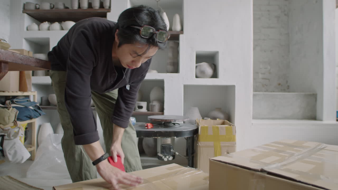 Asian Ceramist Sealing Box with Stuff in Pottery Workshop