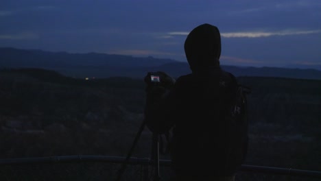 silhouette of a photographer taking a time lapse at bryce point before sunrise.