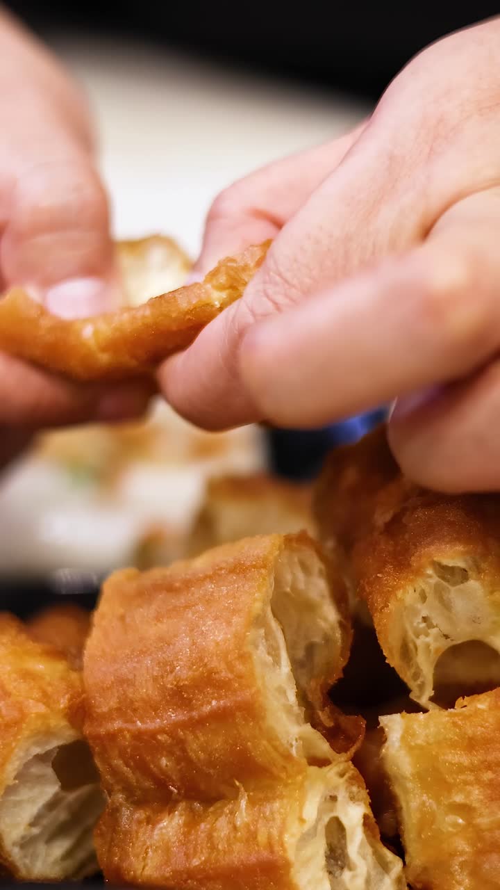 Hands breaking and sharing dough sticks