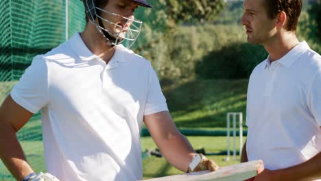Cricketspieler-Interagieren-Während-Einer-Trainingseinheit-In-Den-Netzen-Miteinander