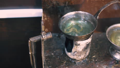 goldsmith processes chain with boiling liquid close view