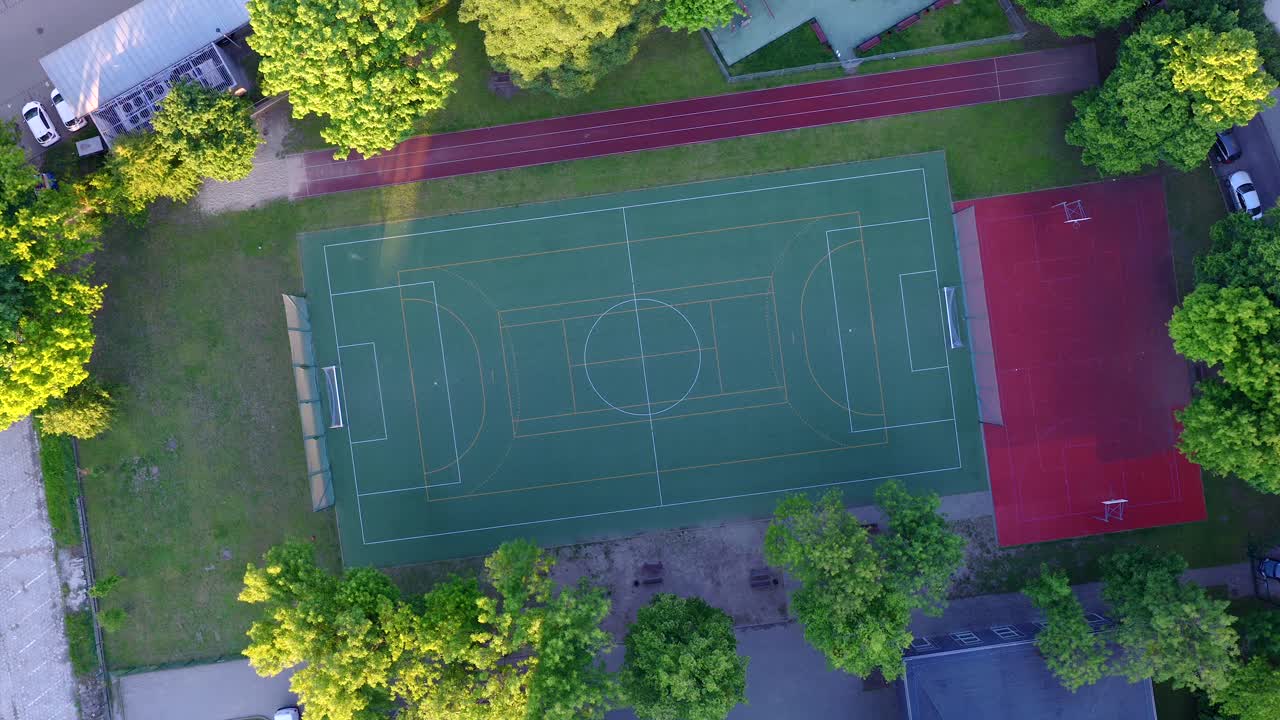 Drone view of Warsaw school sports field, basketball and football area, summer vibe