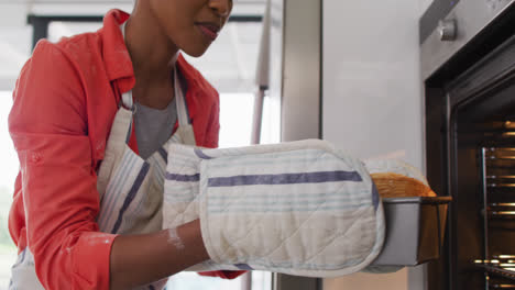 Video-of-african-american-woman-taking-out-cake-from-oven