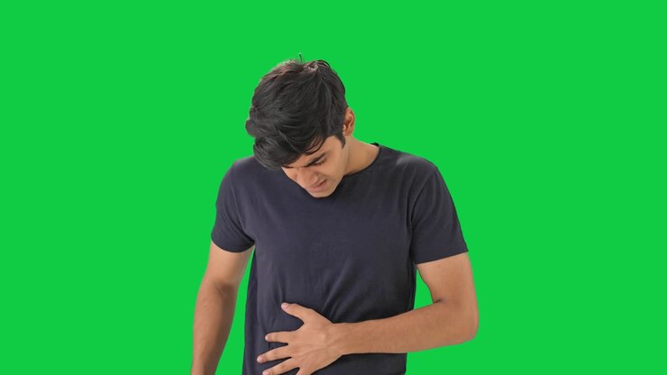 joven indio con dolor de estómago pantalla verde