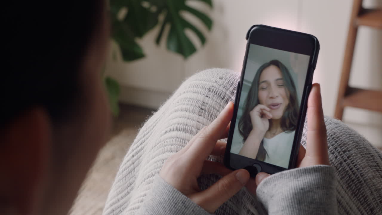 mujer joven teniendo video chat usando teléfono inteligente en casa hablando con un amigo disfrutando de la conversación compartiendo estilo de vida en el teléfono móvil