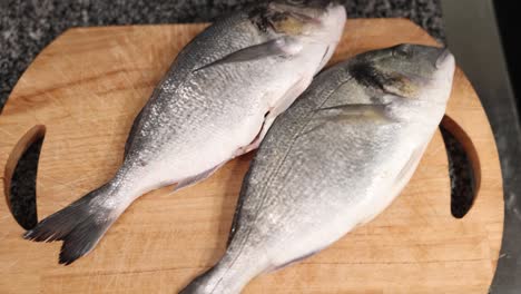 two fresh dorado fish on a wooden cutting board