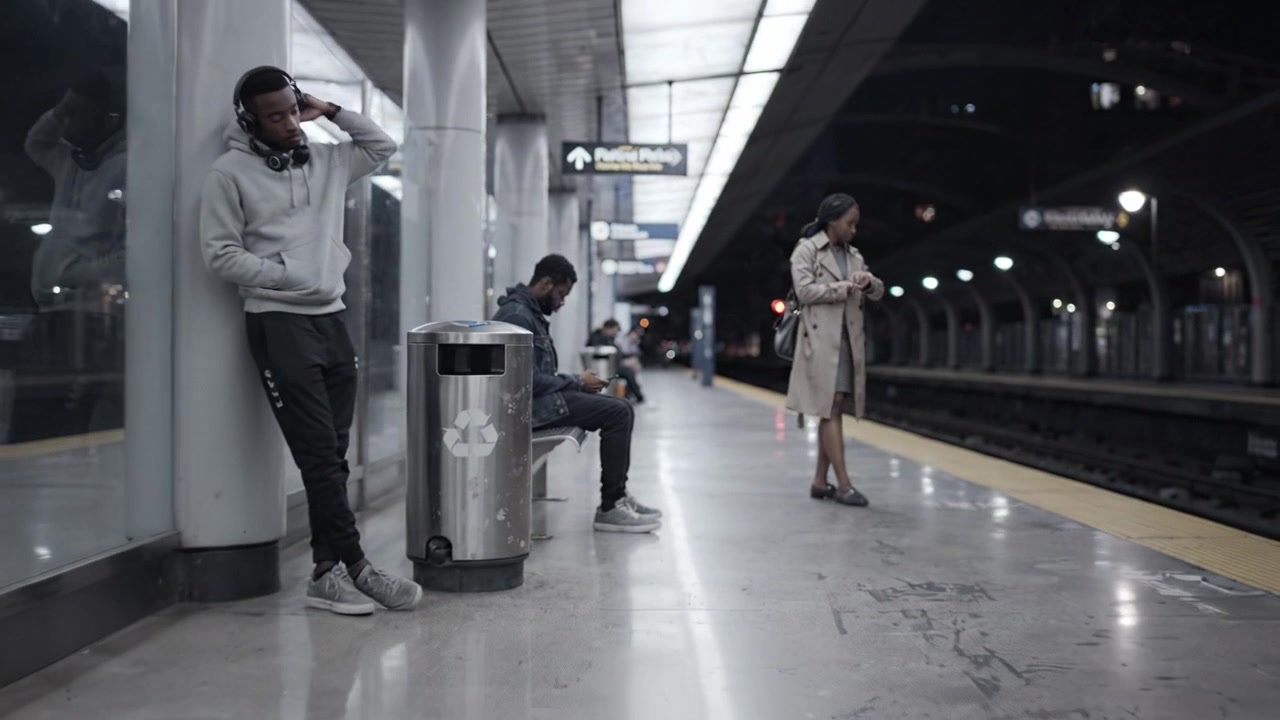 Et stille øjeblik på metrostationen: To personer viser deres handlinger i en fængslende bymæssig ramme med byens lys' nattelys ovenover.