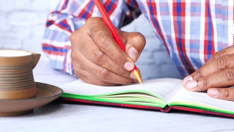 persona que escribe en un cuaderno