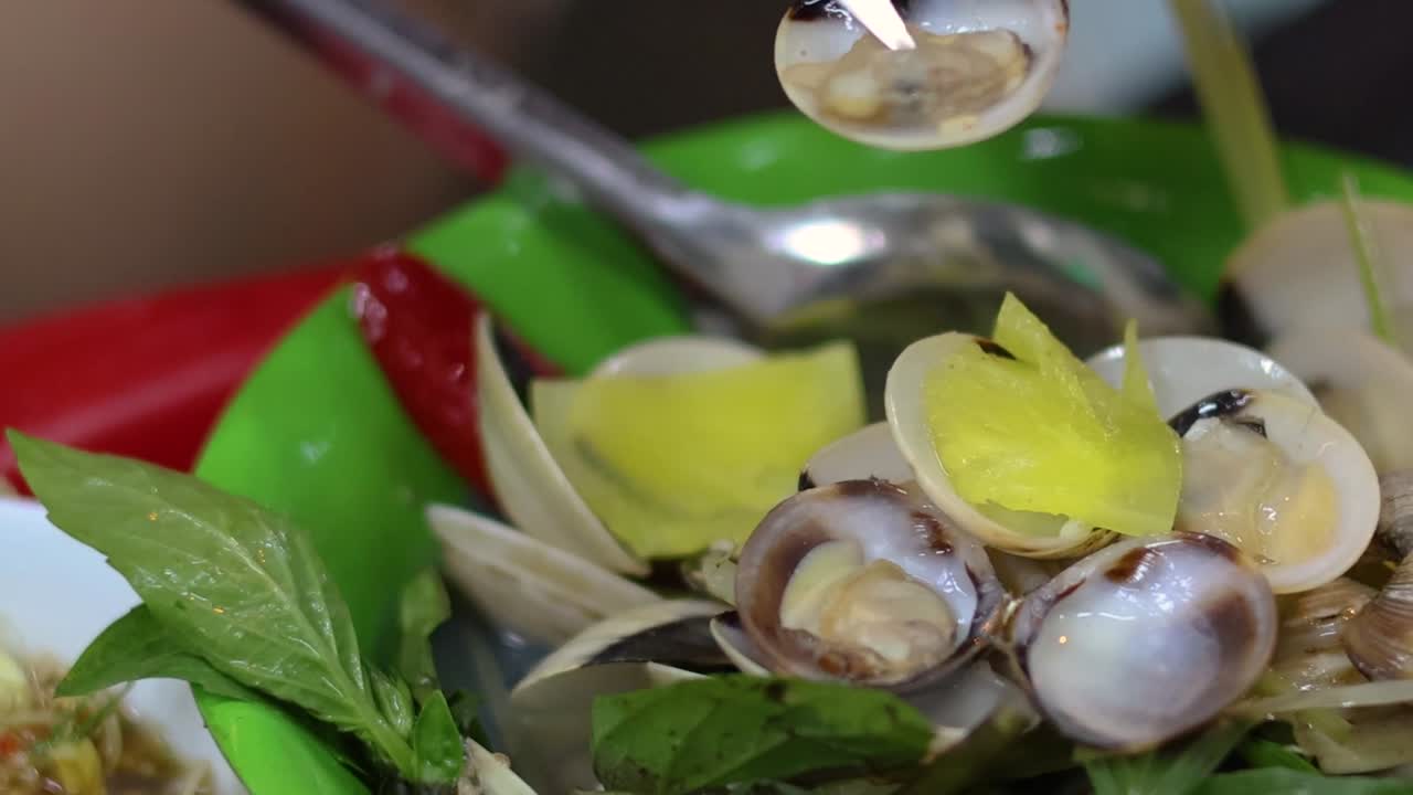 손은 그 위에 칼로 조개를 벗기고 있습니다.