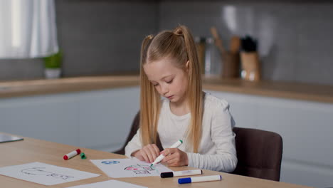 young girl drawing and coloring at a table