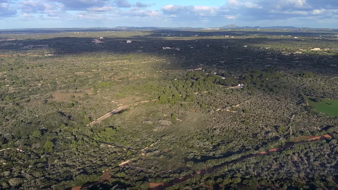 vista aérea do lado esquerdo da sombra de um avião a jato durante a aproximação final ao aeroporto de Menorca, sobre uma paisagem plana e rural