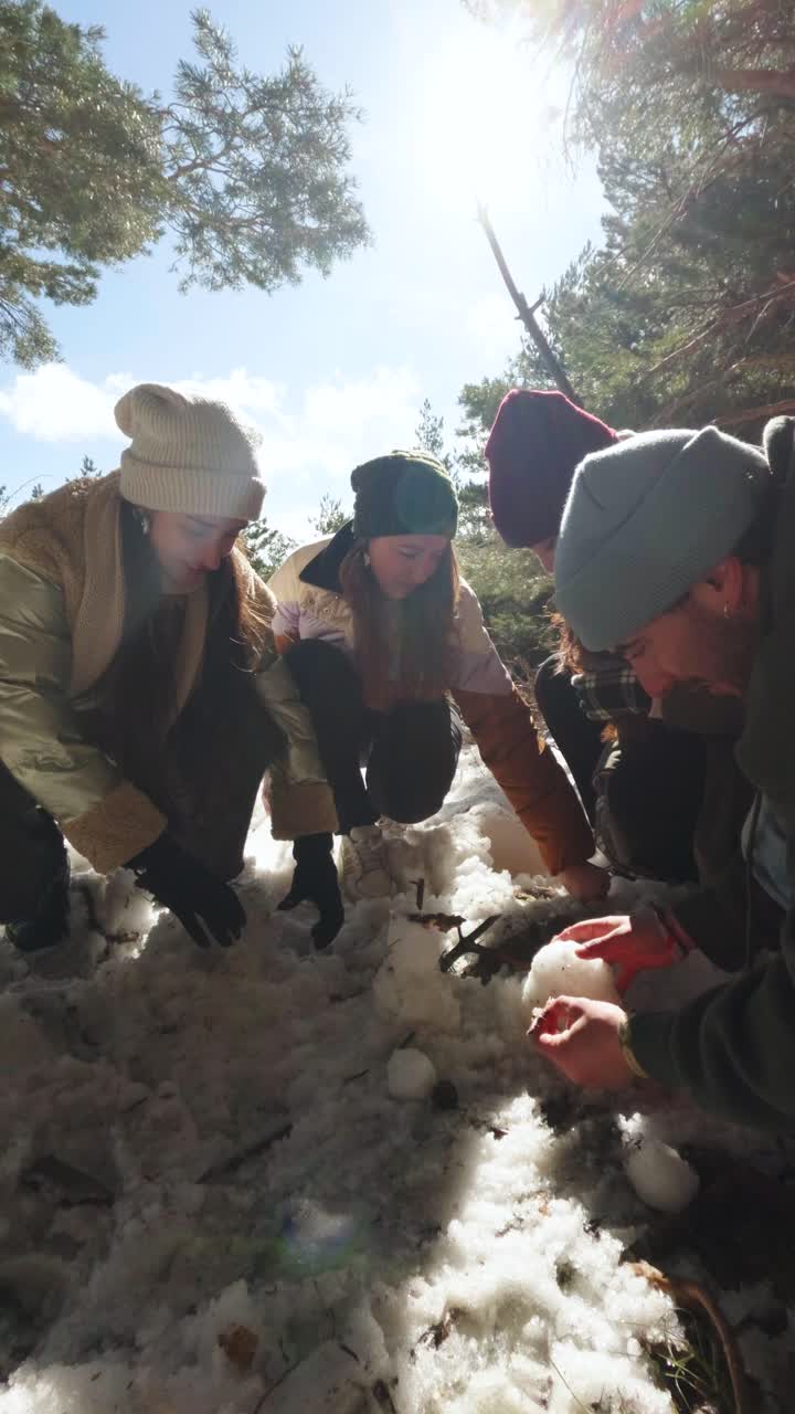 Group of friends making a snowman in the snow