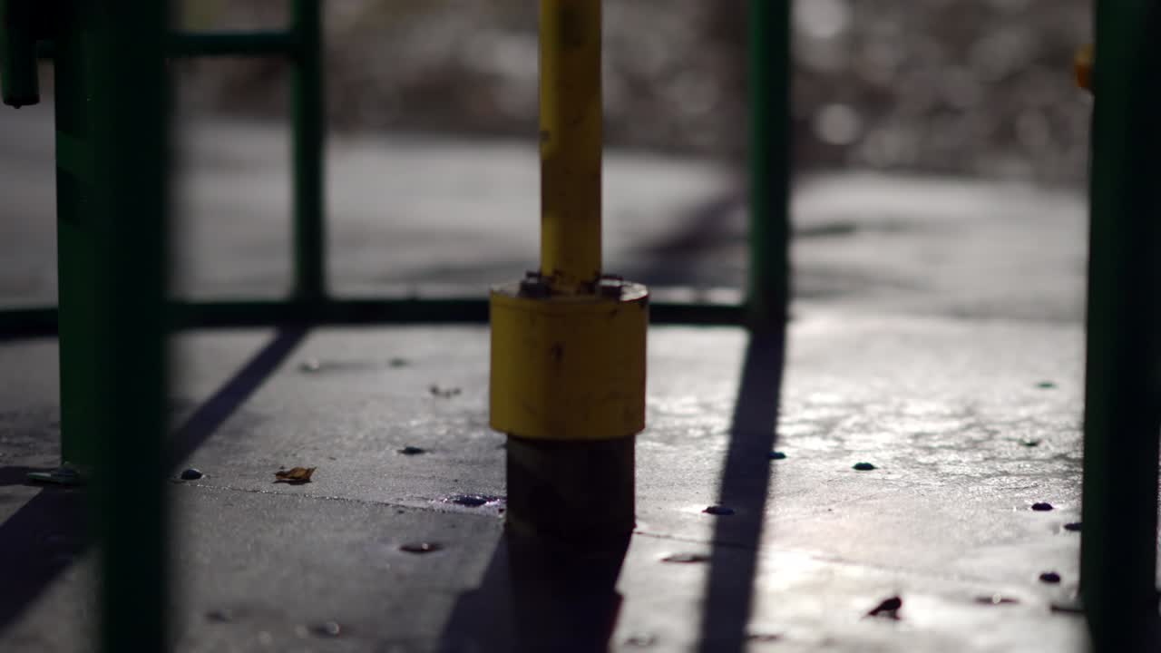 un carrusel húmedo girando en el patio de juegos vacío de los niños en el parque de la ciudad en una noche de otoño.