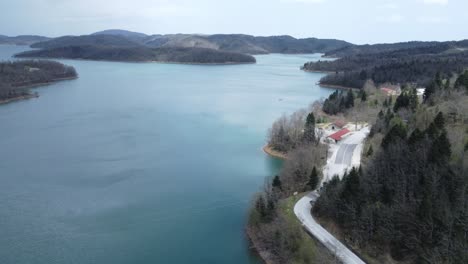 backward slow aerial shot over lake plastira in central greece | 4k