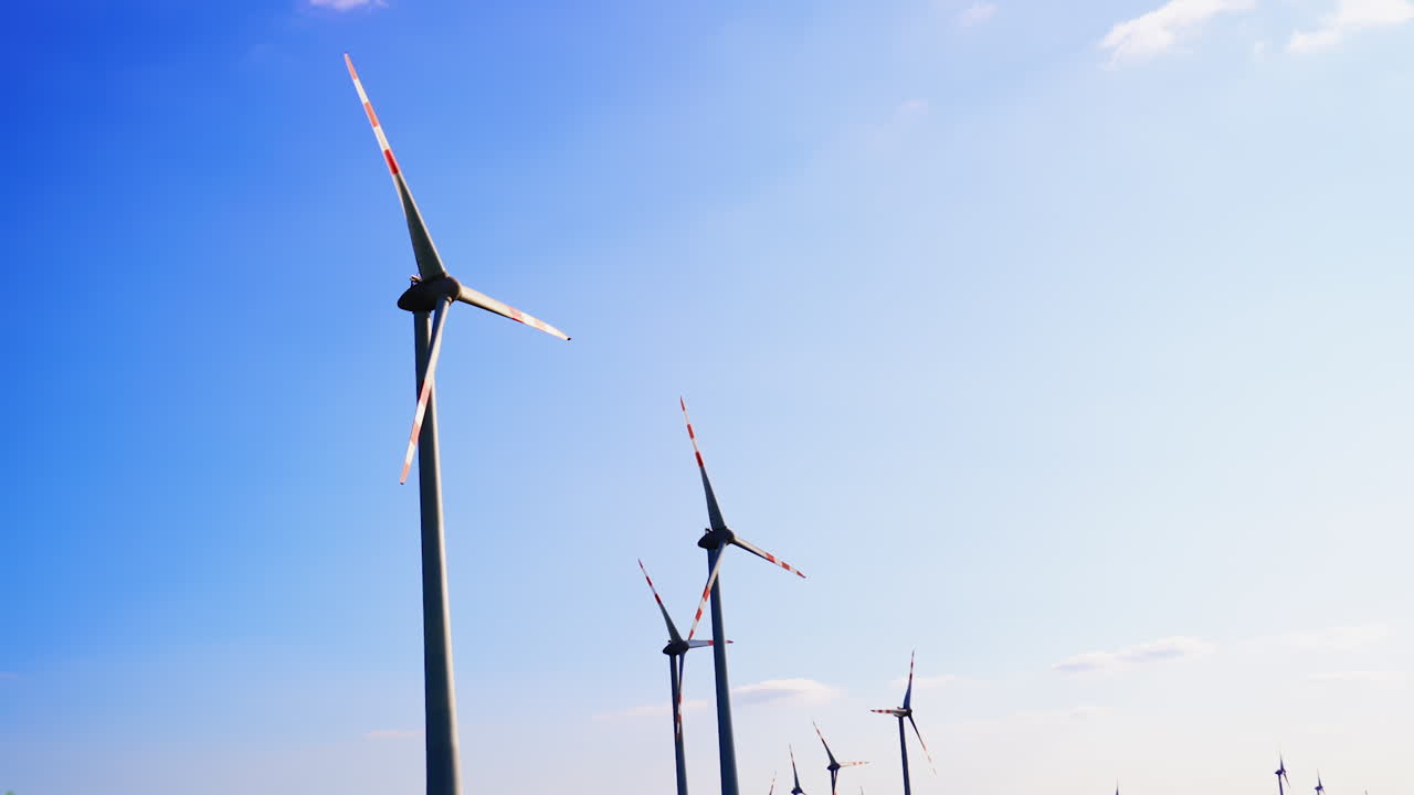 Turbines in bright sky. Wind turbines spin in a clear sky, harnessing wind power for clean electricity generation