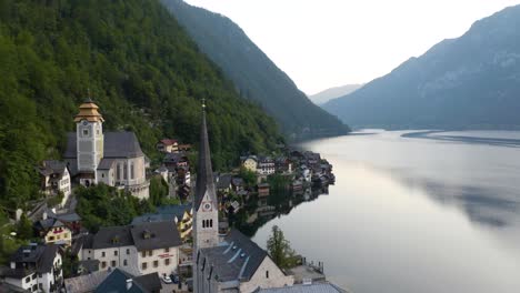 establecimiento lento de vuelo sobre la iglesia en hallstatt, austria - región de salzkammergut