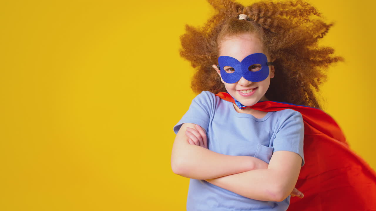 retrato de estudio de una niña vestida como superhéroe de cómics contra un fondo amarillo