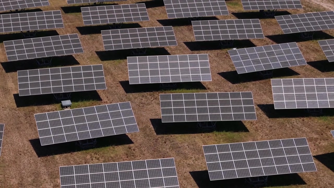 Vista dall'alto di pannelli solari che ruotano in un parco solare. Concetto di energia rinnovabile con celle fotovoltaiche che raccolgono la luce solare per energia sostenibile.