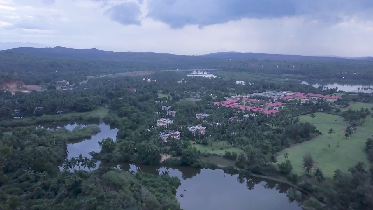 Drone Flying Towards The LaLiT Golf And Spa Resort In Raj Baga, Palolem, Canacona, Goa, India On A Cloudy Day - aerial drone shot