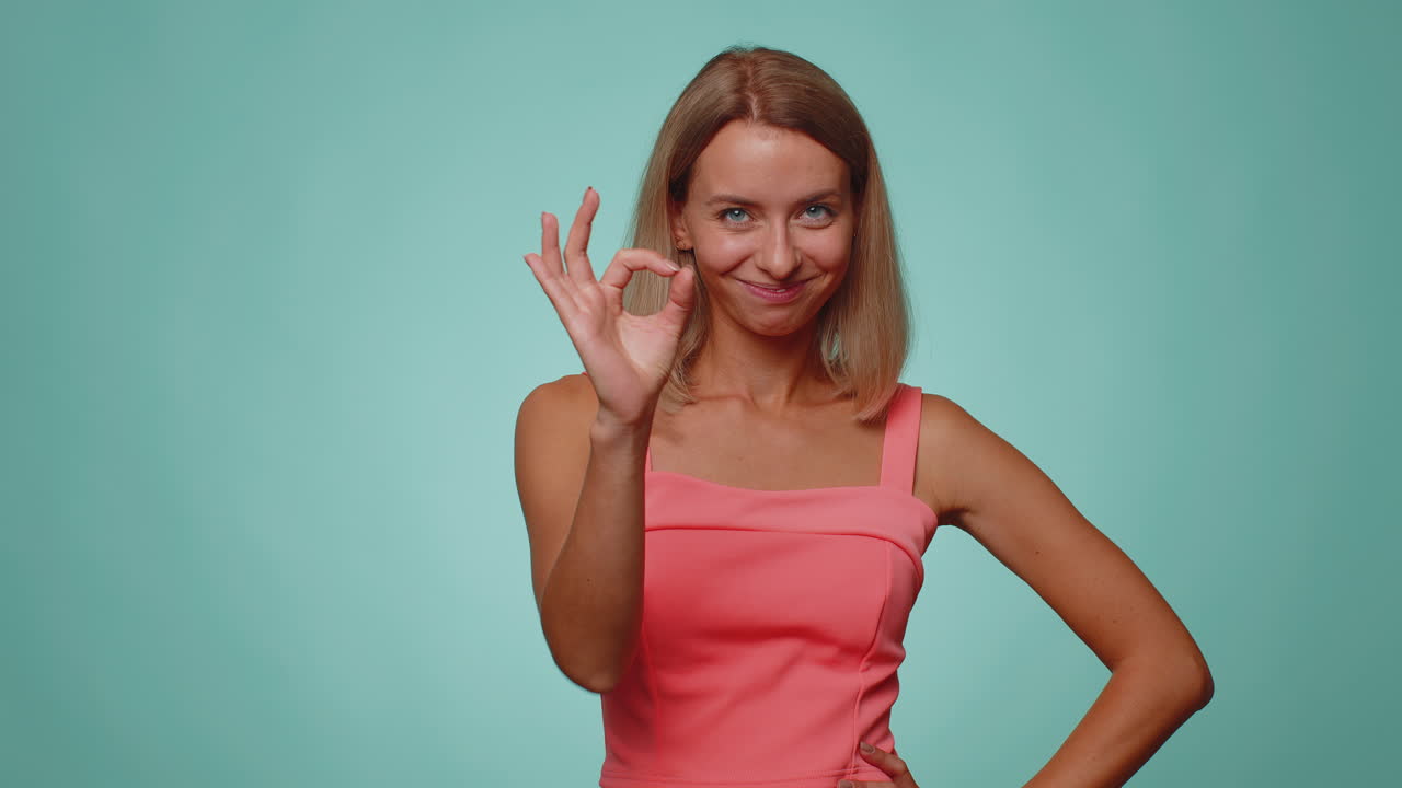 여성은 긍정적으로 보이며,  ⁇ 을 보여줍니다. 긍정적 인 무언가를 표시하는 것과 같은 피드백 제스처를 승인합니다.