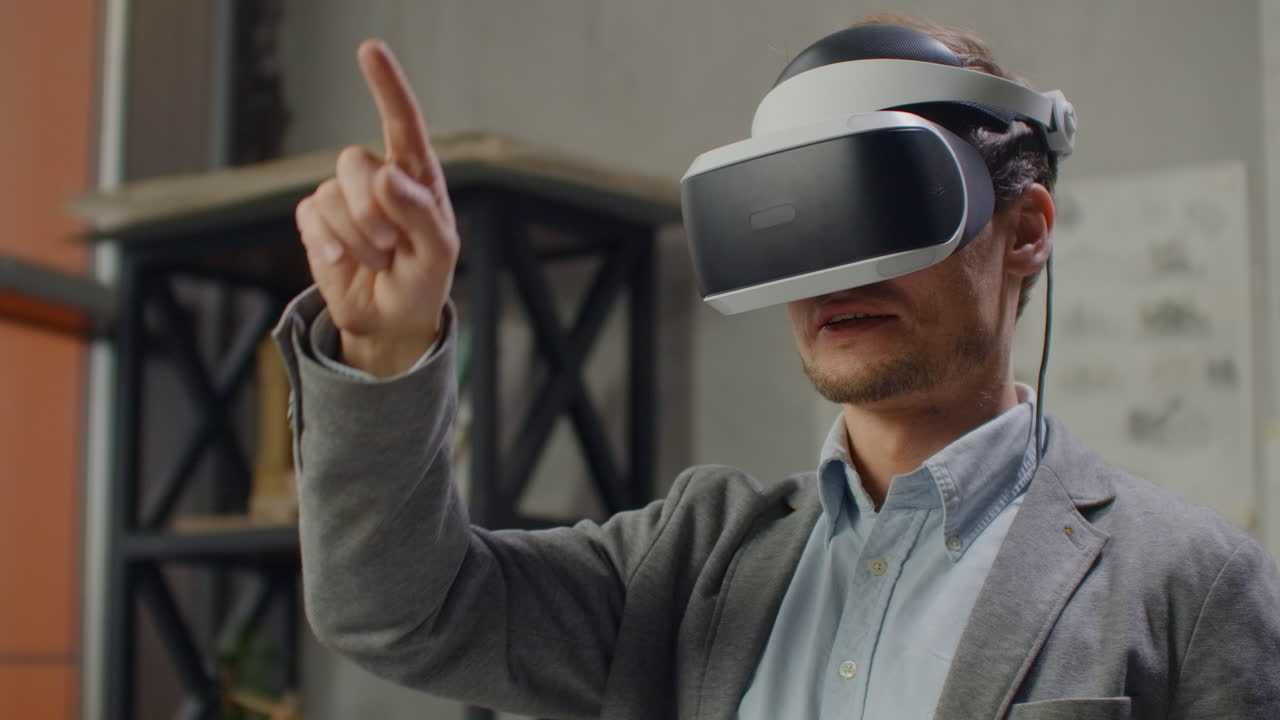 male engineer in virtual reality helmet with hands imitates work of interface. Designing the future the concept of virtual architecture and design interface graphic applications.