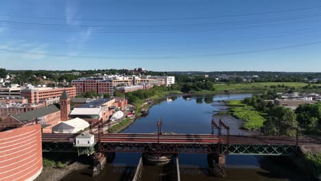 an aerial view over the norwalk river railroad bridge on a sunny morning