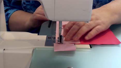 a woman sews a seam on a sewing machine