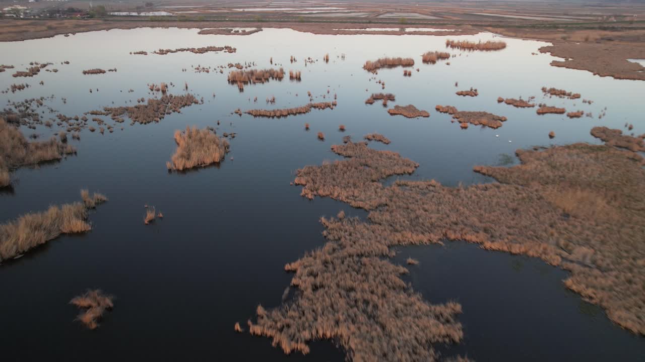 el lago comana muestra islas pantanosas y aguas tranquilas al atardecer, vista aérea
