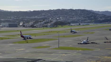 un qantas y un avión airbus a320 de air nz rodando hacia y desde las puertas del aeropuerto de wellington en nz