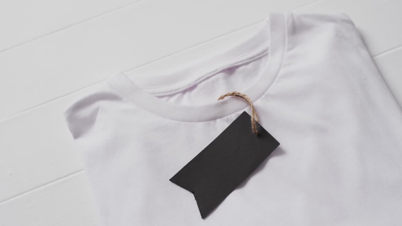 video di strato piatto di maglietta bianca con tag e spazio di copia su sfondo bianco