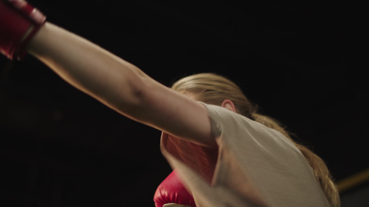 mujer deportiva enérgica haciendo puñetazos en el gimnasio. chica en forma calentándose en el club deportivo