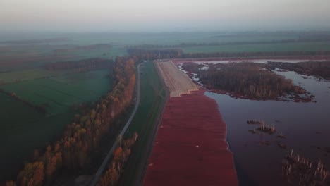 Aerial-view-of-the-misty-scene-of-Red-mud,-red-toxic-sludge-deposits,-Stade,-Lower-Saxony,-Germany