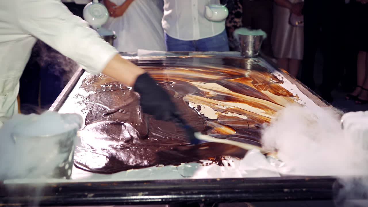 Process of making sweet ice cream with liquid nitrogen for guests. Professional cooking of cold ice-cream in the smoke of liquid nitrogen.