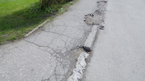 Old-cracked-and-fragmented-asphalt-in-city-street-and-sidewalk