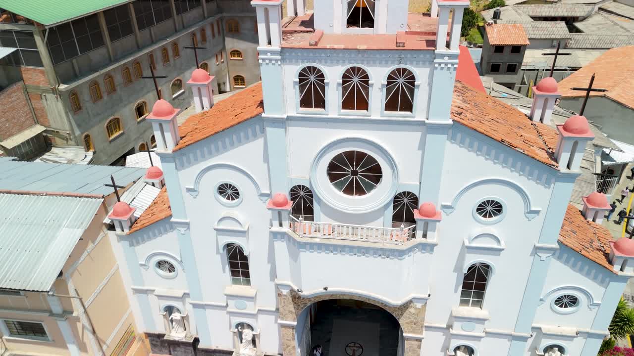 A beautiful aerial shot tilts up to reveal the stunning colonial architecture of the Santuario de la Soledad church, with the city of Huaraz and the Andes mountains in the background