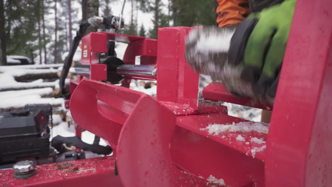 Man Is Cutting Frozen Conifer Woods Using Log Splitter Machine
