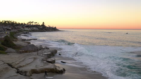 Surfer-warming-up-at-Windansea-beach-during-sunrise