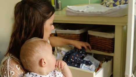 Mother-with-her-baby-boy-looking-clothes-in-drawer-4k