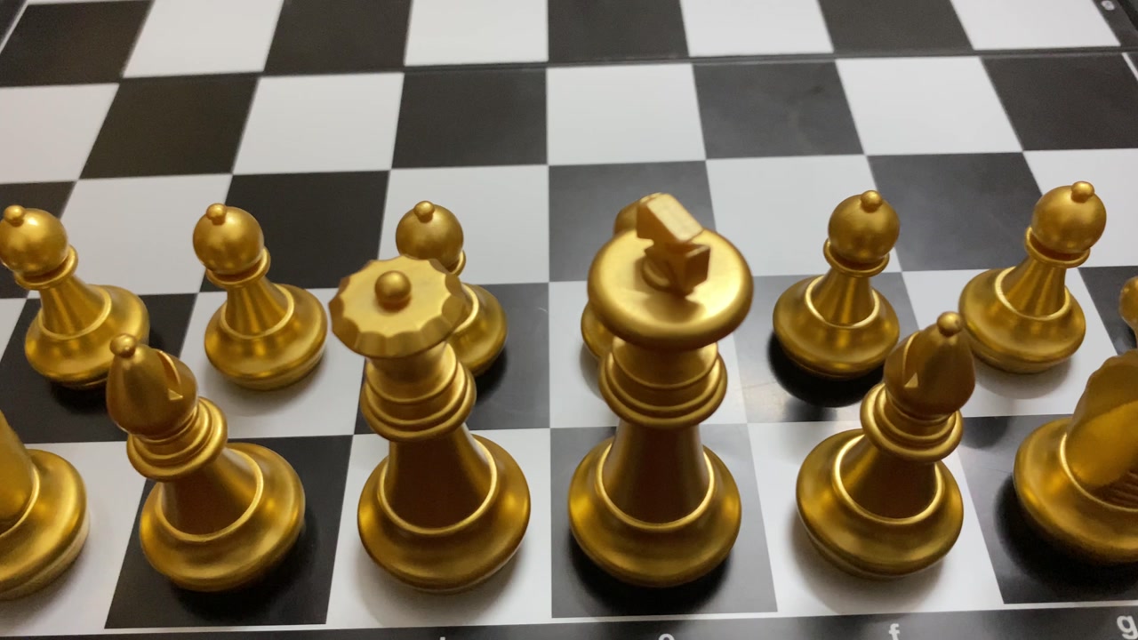 Game concept: Golden colored chess pieces arranged for opening match - close up shot.