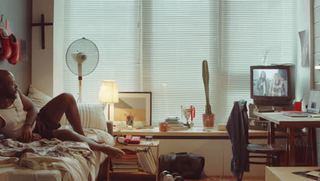 african american man watching tv news at home