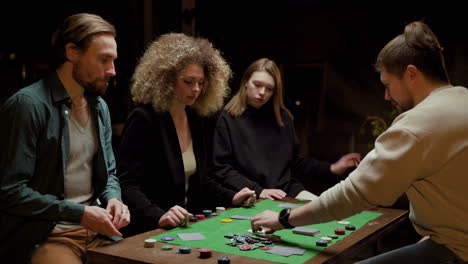 group of friends playing poker sitting on chairs at a table