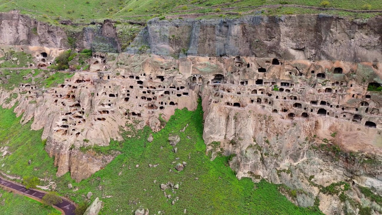 Panoramica aerea del monastero rupestre di Vardzia, Georgia. Spettacolare antico sito sacro scavato nelle pendici del monte Erusheti sopra il tortuoso fiume Mtkvari.