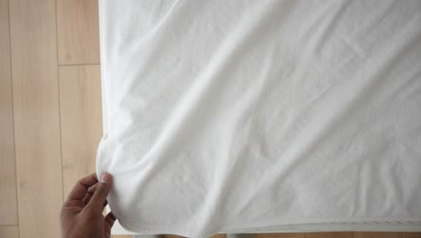 close-up of a person holding a fitted sheet