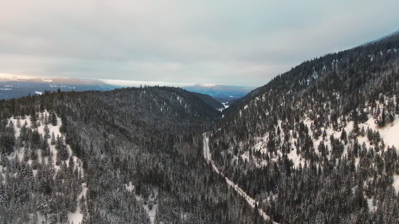 invierno místico: hermoso tiro de retroceso de drones de montañas cubiertas de árboles nublados y brumosos en la región de thompson-nicola, bc, canadá