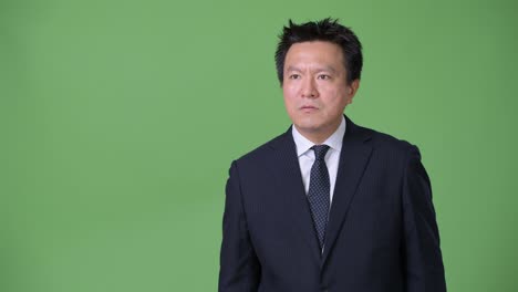 녹색 배경에 성숙한 일본 사업가