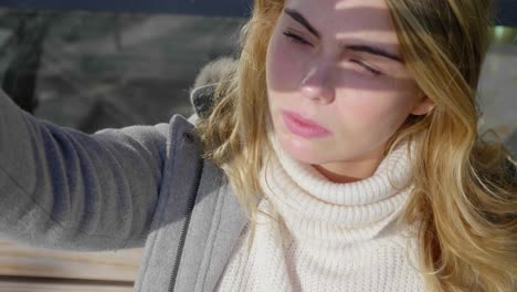 beautiful blonde woman uses her hand to shade her eyes from the sun