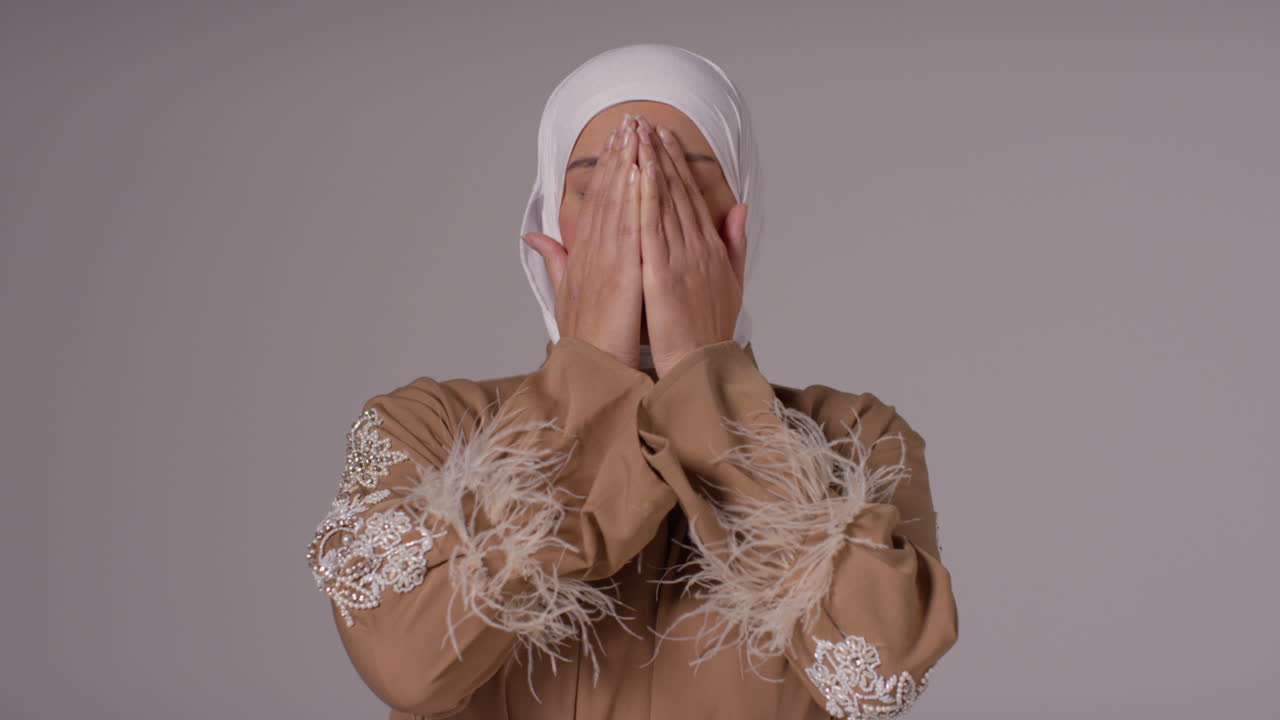 머리와 어깨: 히자브를 입고 기도하는 무슬림 여성의 초상화