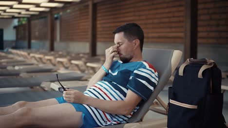 man relaxing by the pool